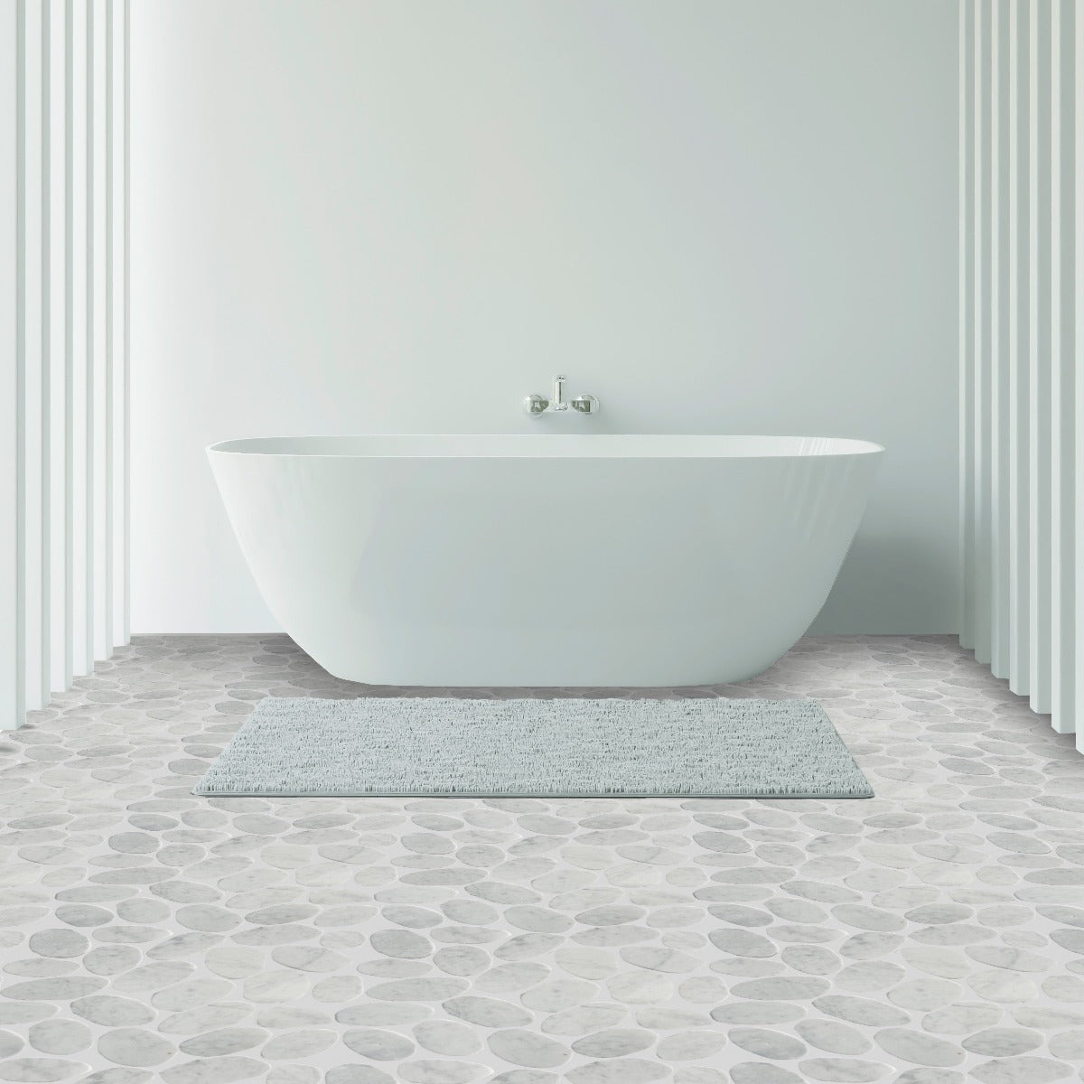 XL Slice Carrara tile flooring with white bathtub and bathmat on top of it