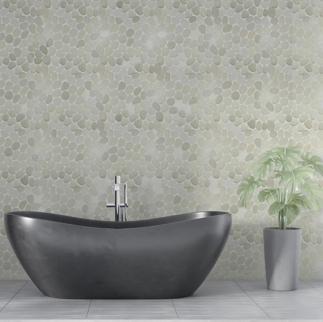 White pebble tile wall with grey bathtub and small plant in front of it
