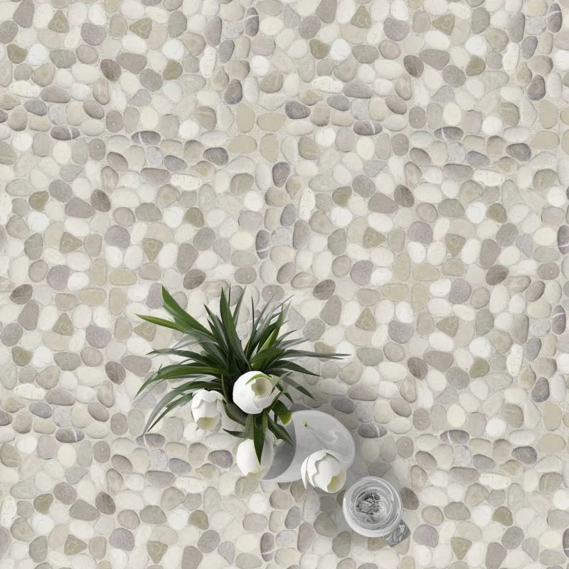 Seasalt pebble tile flooring with white tulips in a vase on top